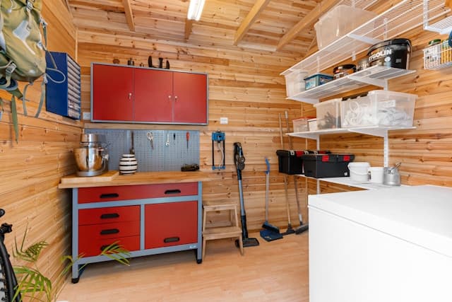 Warm wood-panelled garage workshop with red workbench and shelving